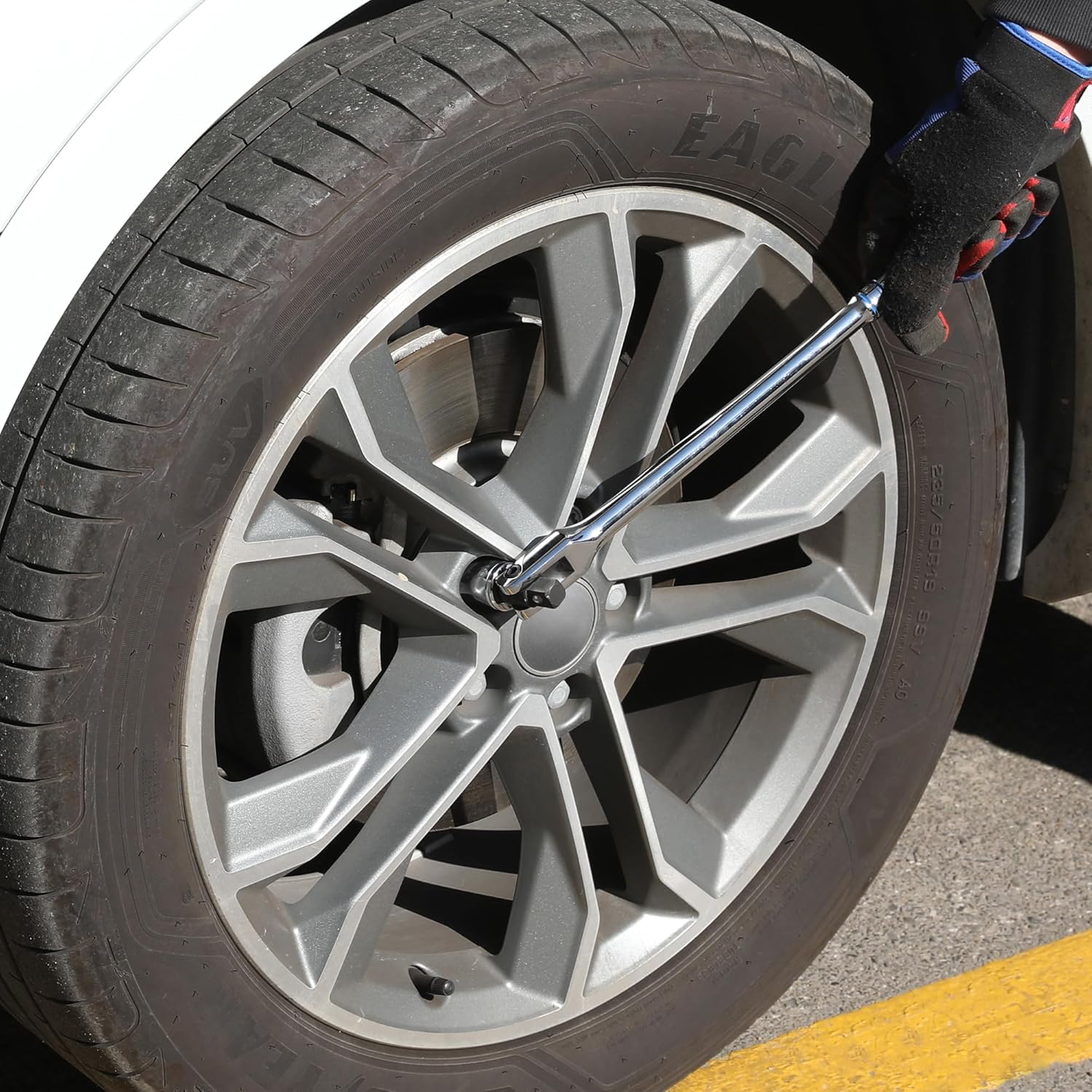 WORKPRO breaker bar engaged on a wheel lug, chrome handle and socket drive head
