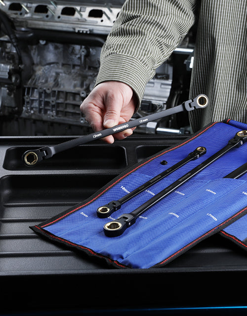 Mechanic hand using a wrench and tools on a car engine bay with blue tool roll for quality innovation