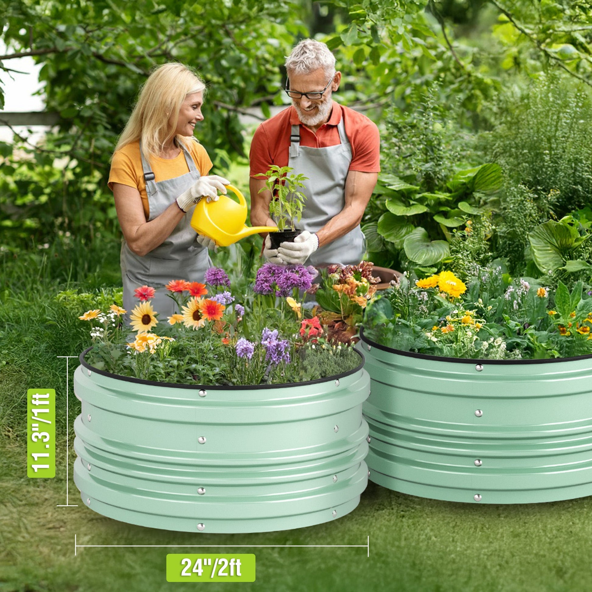 Green raised garden bed with flowers and vegetables, two gardeners watering.
