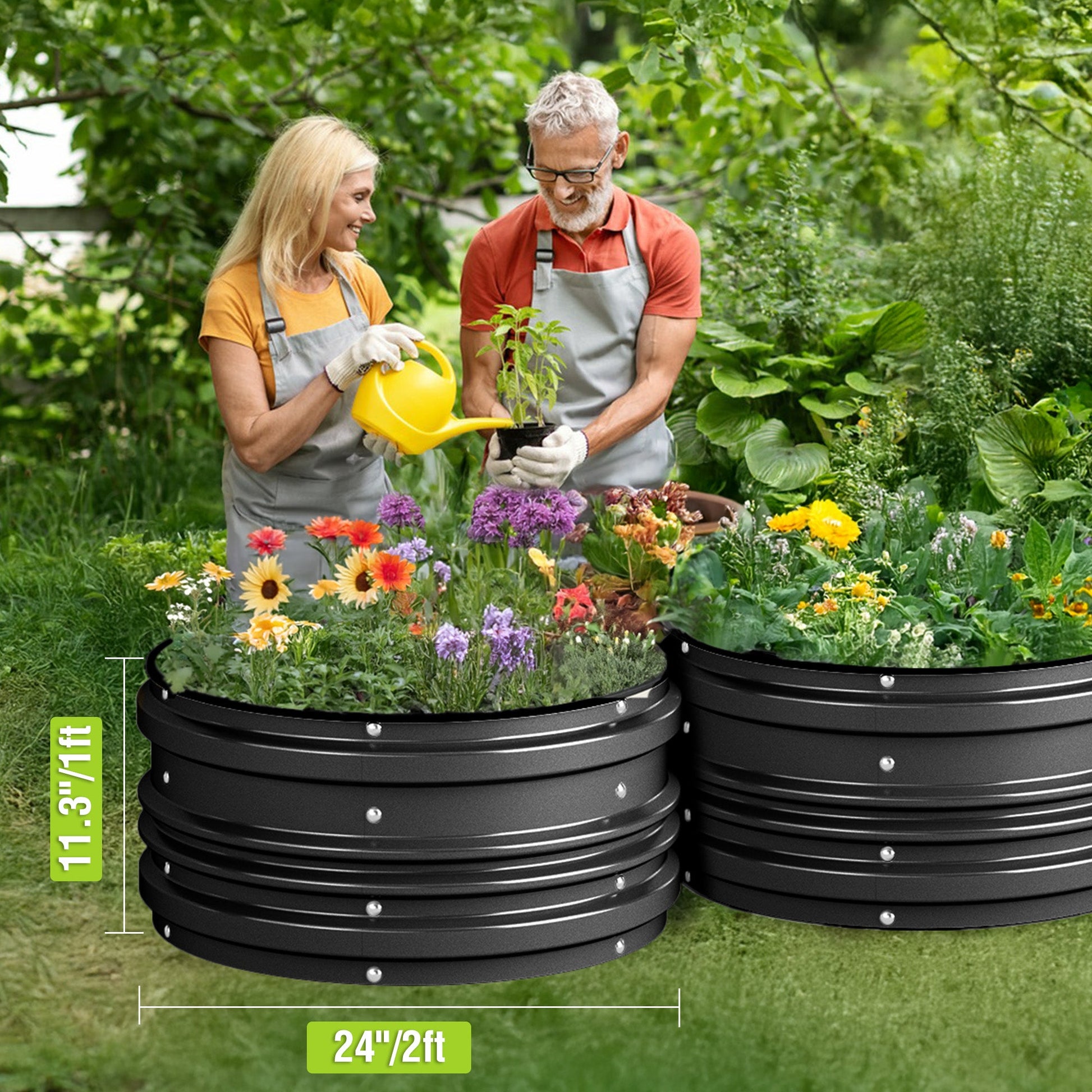 Black raised garden beds in a yard with flowers and vegetables, being watered