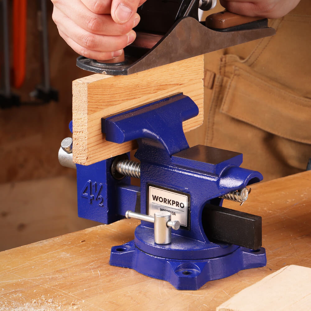 Blue bench vise holding a wooden board with a hand tightening a clamp, showing innovation and quality