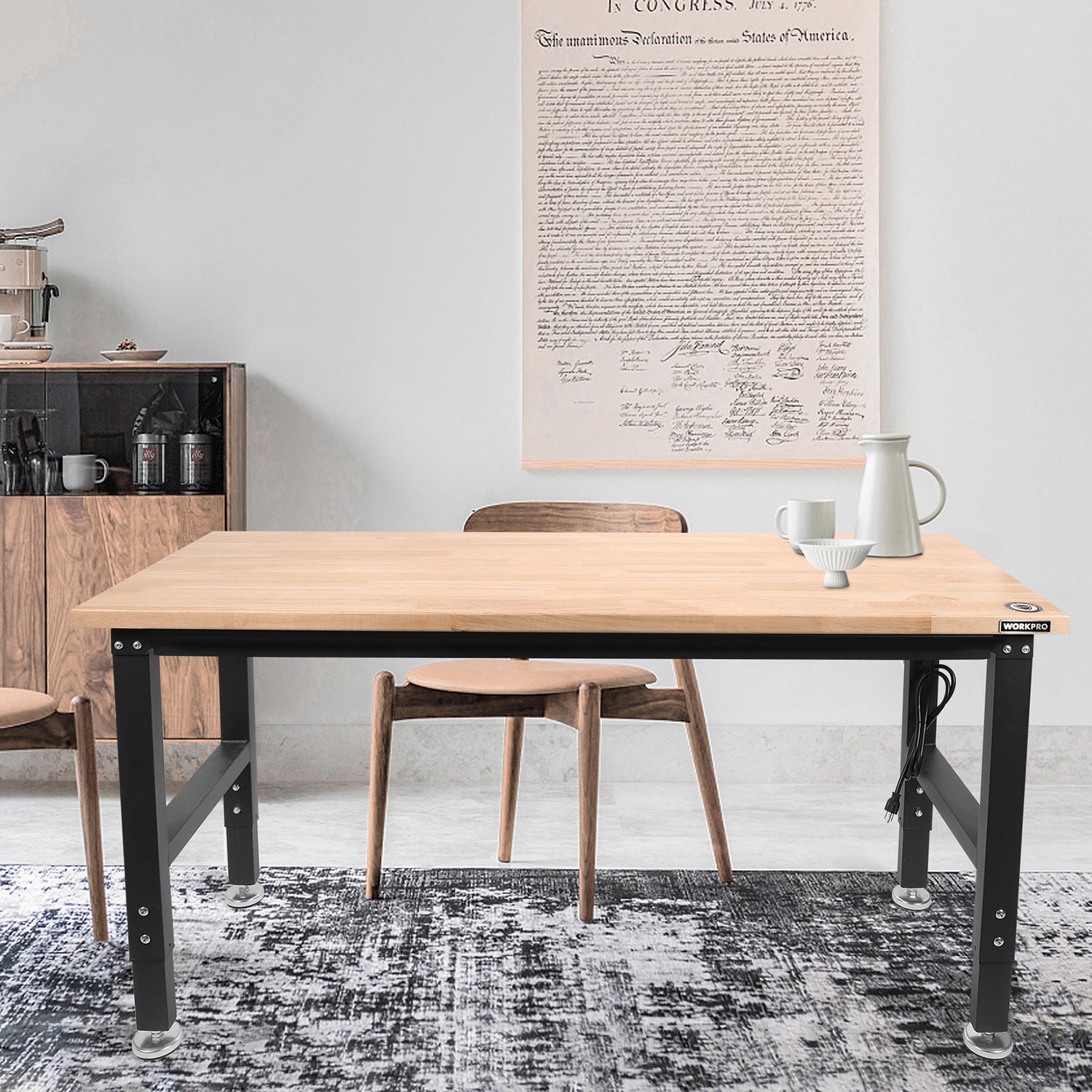 Adjustable workbench with light wood top and black legs in a home workspace
