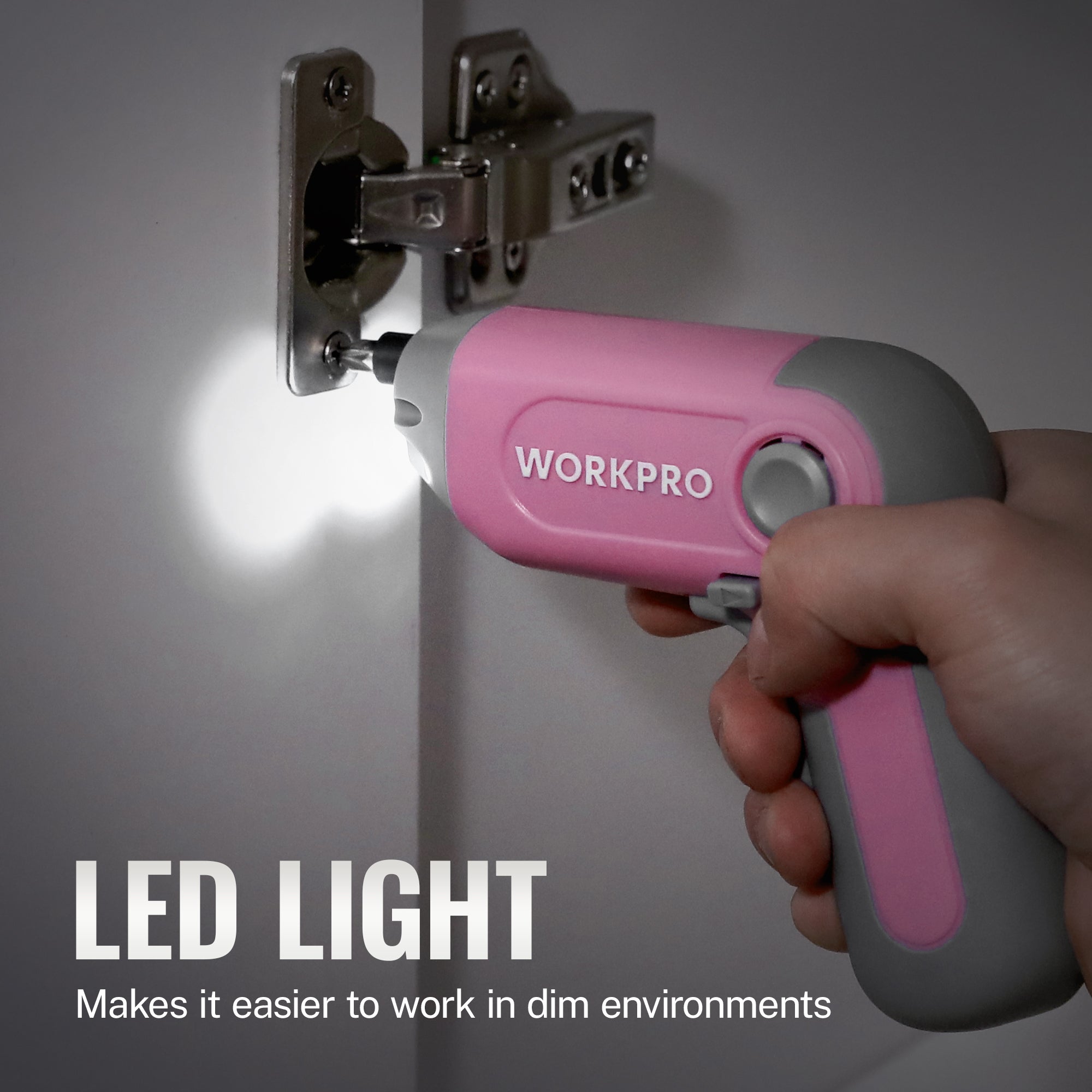 Hand holding pink Workpro screwdriver with LED light illuminated during use