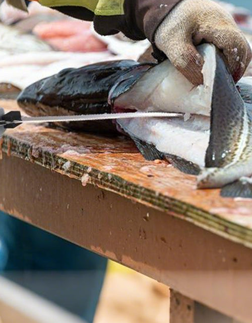 Worker cleaning a fish on a wooden cutting board, with innovation and quality in secure, durable handling