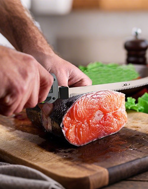 Hands slicing raw salmon on a wooden board with a knife, showing innovation and quality in food prep