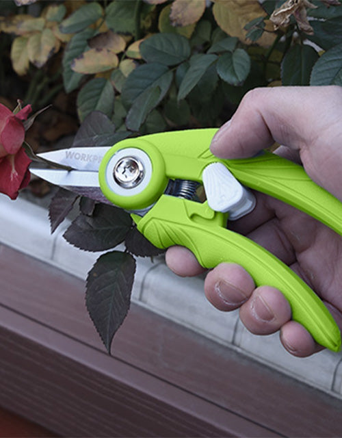 Green folding utility tool with a metal blade, innovation and quality details in a hand outdoors