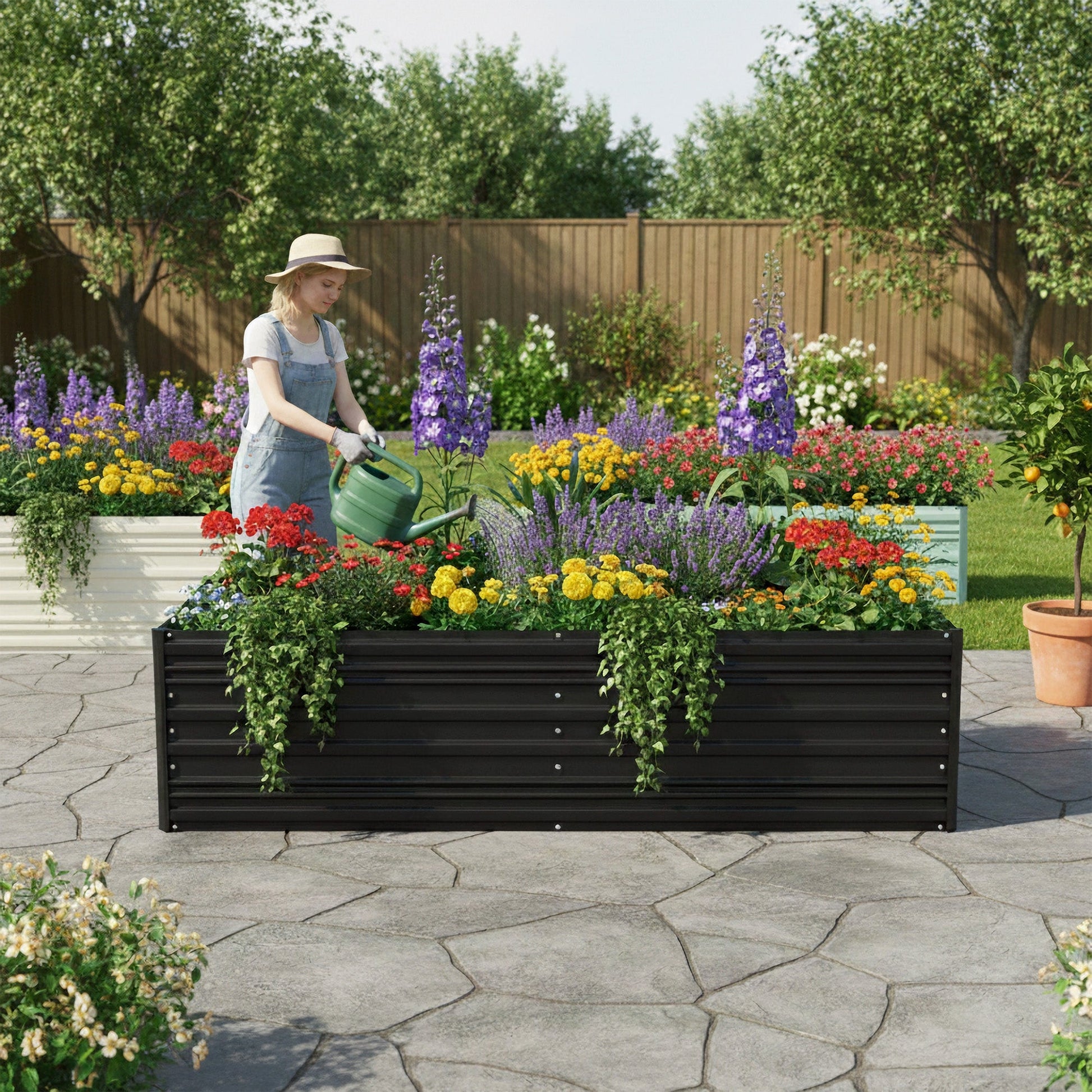Black metal raised garden bed with flower plants on a patio walkway