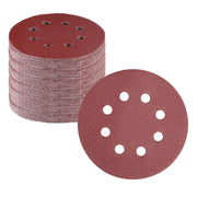 Red 5-inch hook-and-loop sanding discs, stacked, with 8 dust holes