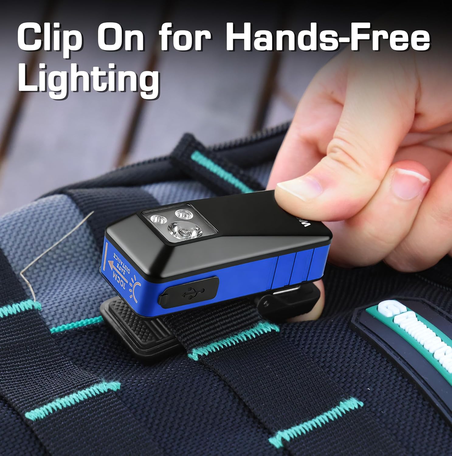 Clip-on rechargeable flashlight, blue and black, lying on fabric with front LED array.