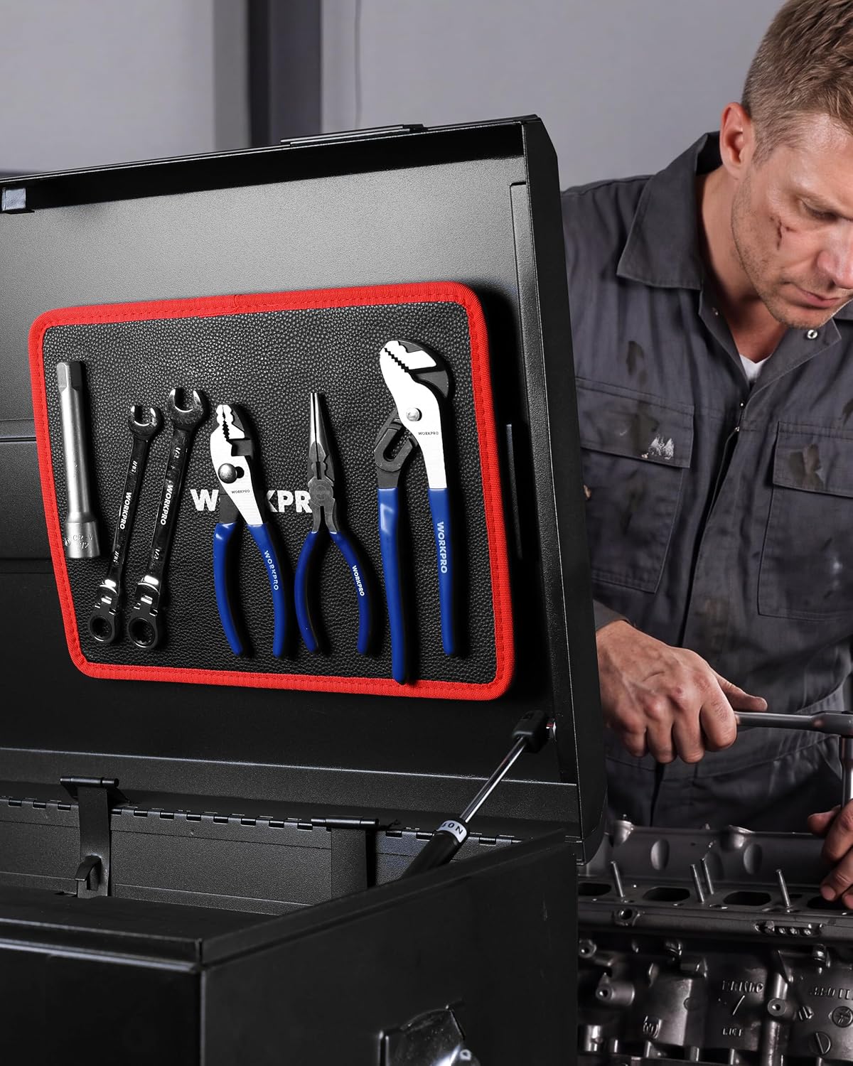 Flexible magnetic tool tray inside workshop drawer, holding tools; black surface with red border.