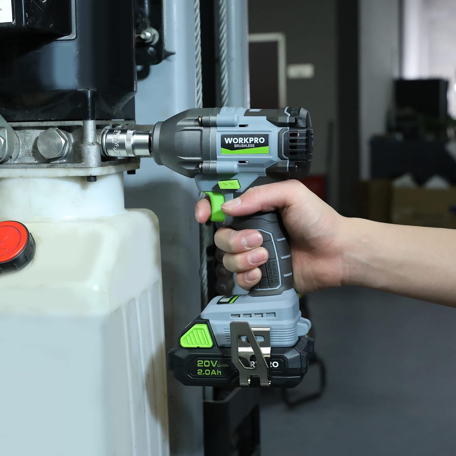 Hand using WORKPRO 20V cordless impact wrench on a bolt near the engine
