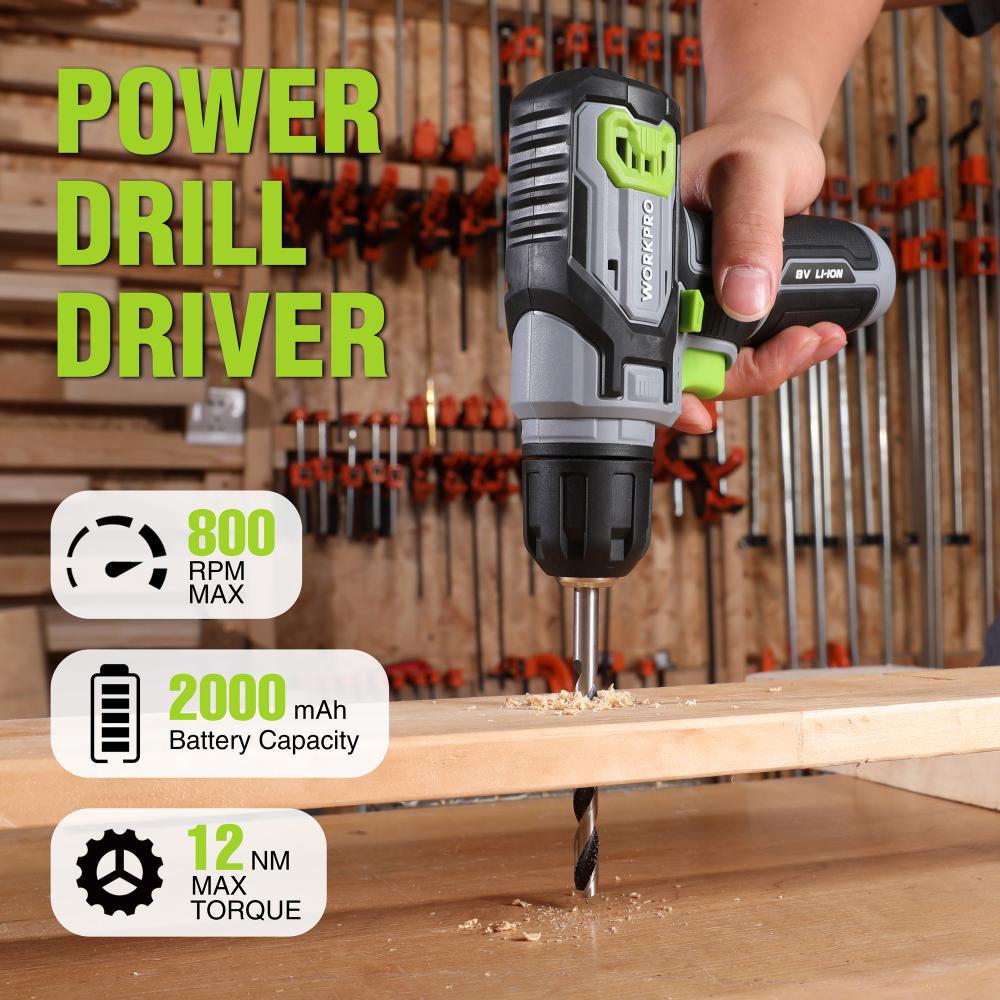 Cordless drill driver with green grip and battery, drilling into wood