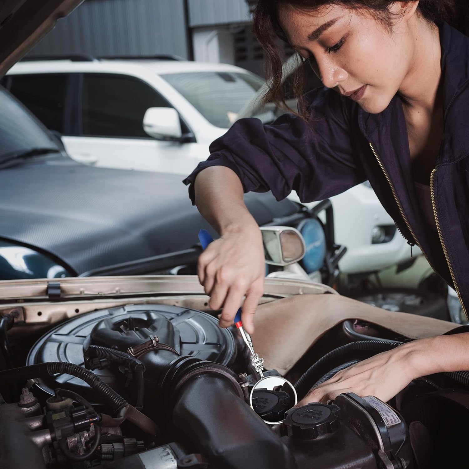 Blue-handled magnetic pickup tool used to pick parts near a car engine bay