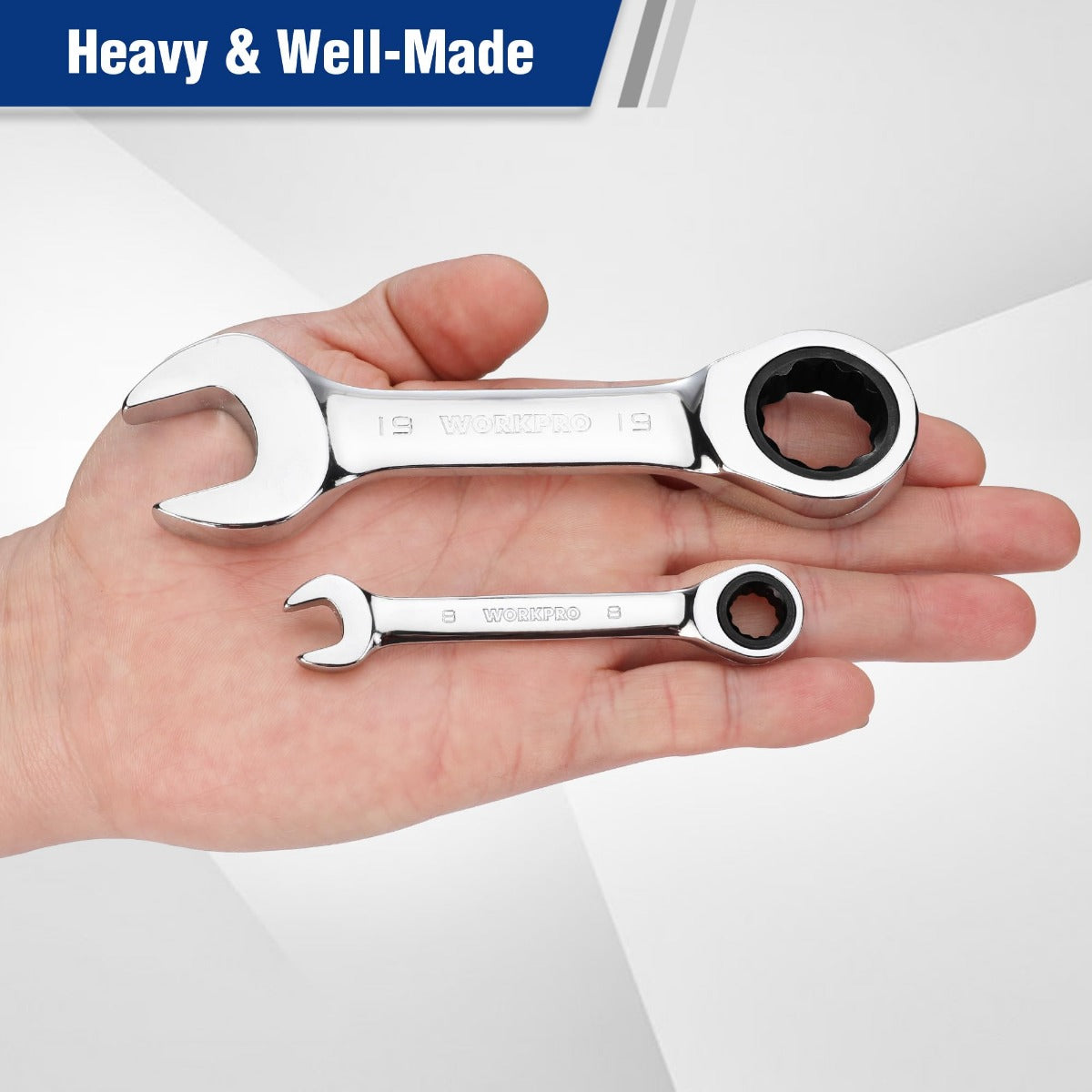 Two stubby ratcheting box-end wrenches held in hand, chrome steel finish
