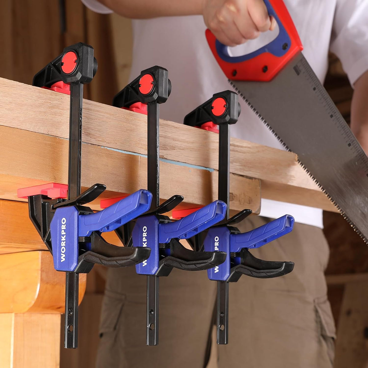 WORKPRO mini bar clamps holding wood, blue grips and red jaw pads