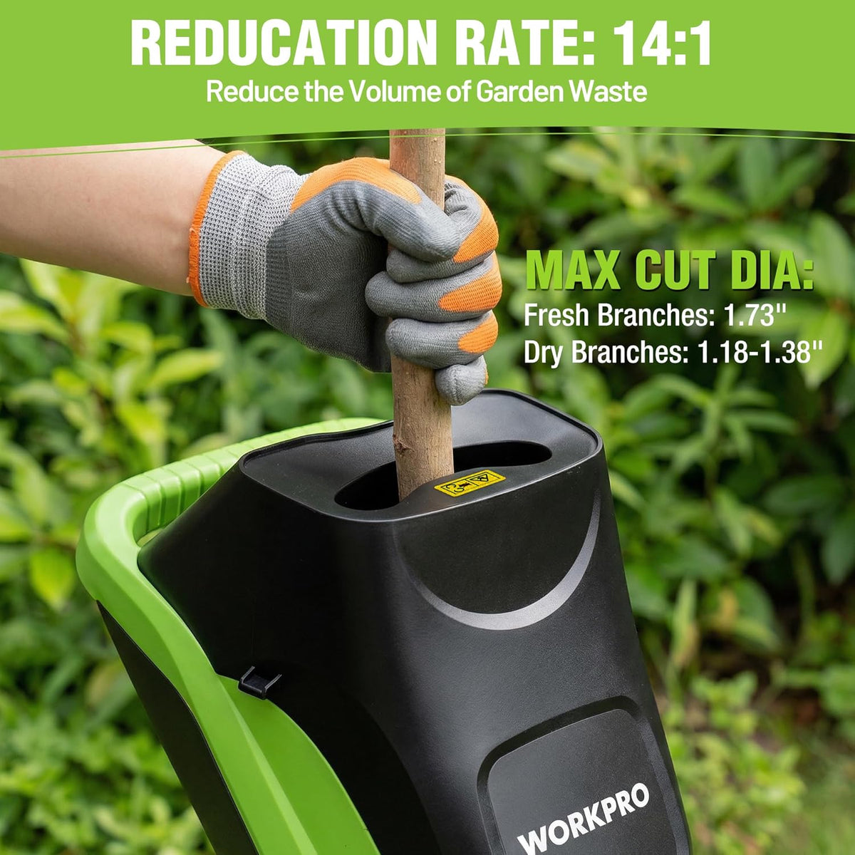Electric branch shredder with hopper; gloved hand feeds a log into the inlet.