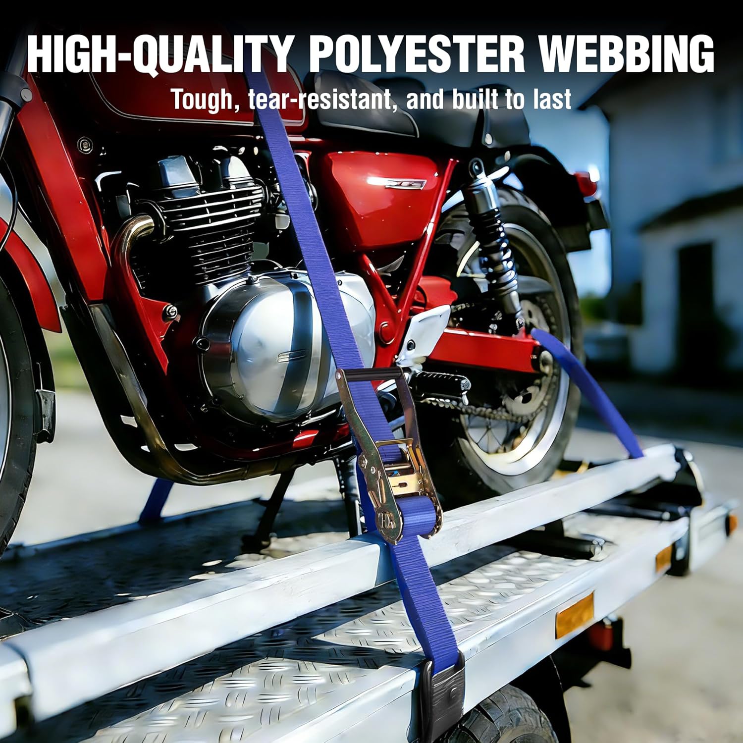 Blue ratchet tie-down strap securing a motorcycle on a trailer platform