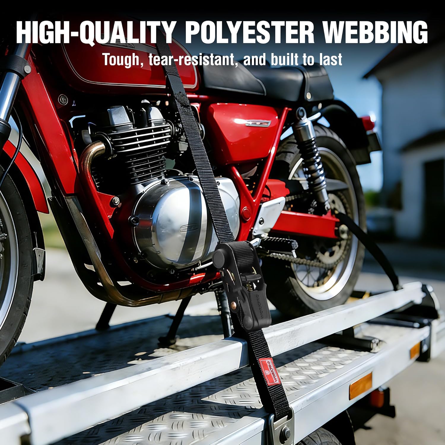 Black polyester webbing ratchet strap securing motorcycle on a trailer rack