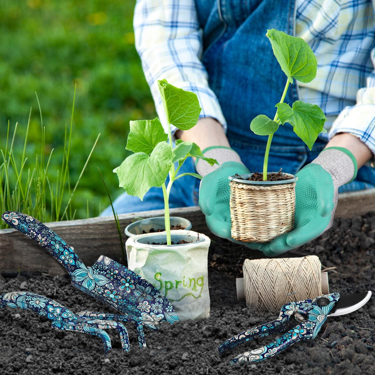 Gloved hands planting seedlings in soil with blue floral garden tools