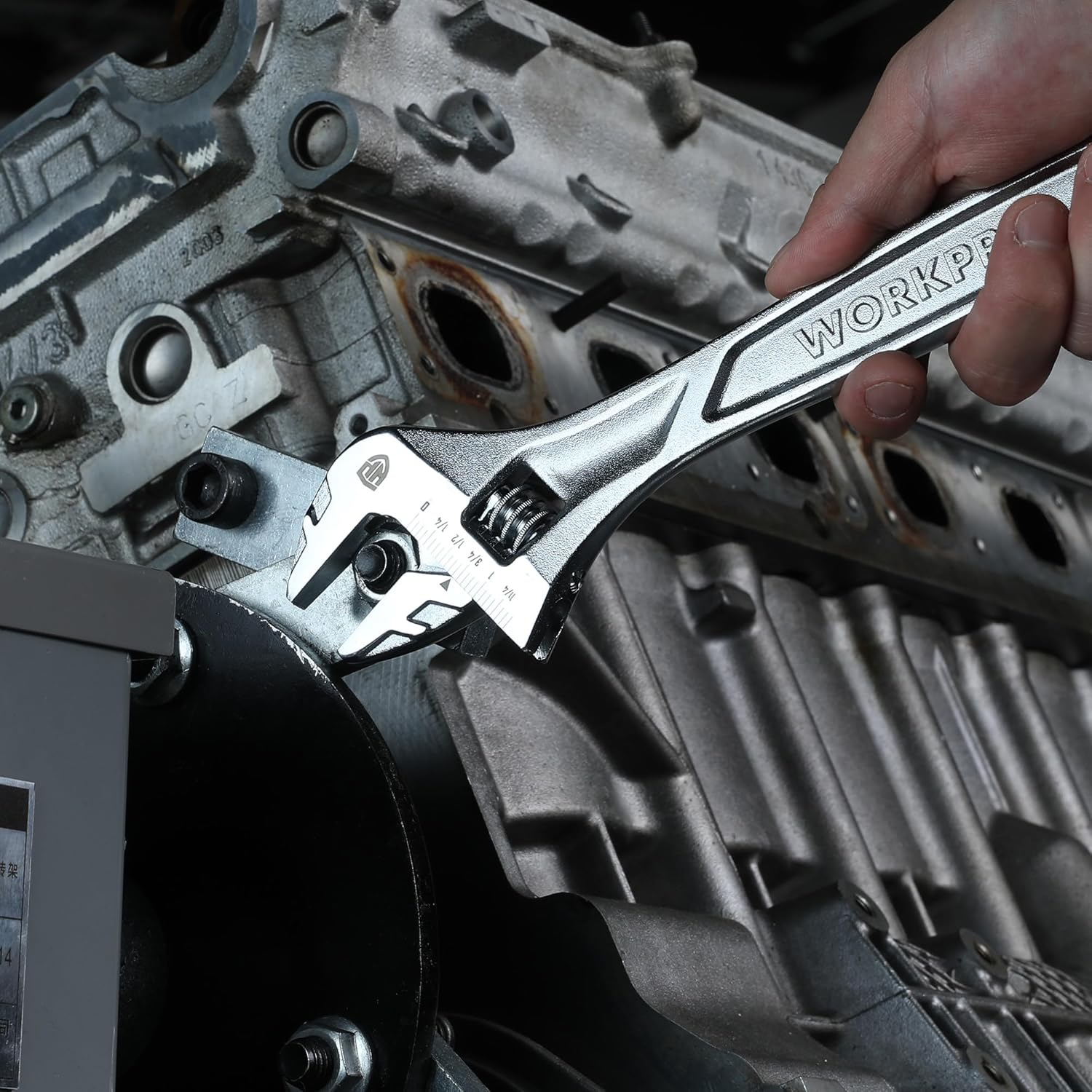 Adjustable wrench on metal engine parts with WORKPRO handle and worm gear
