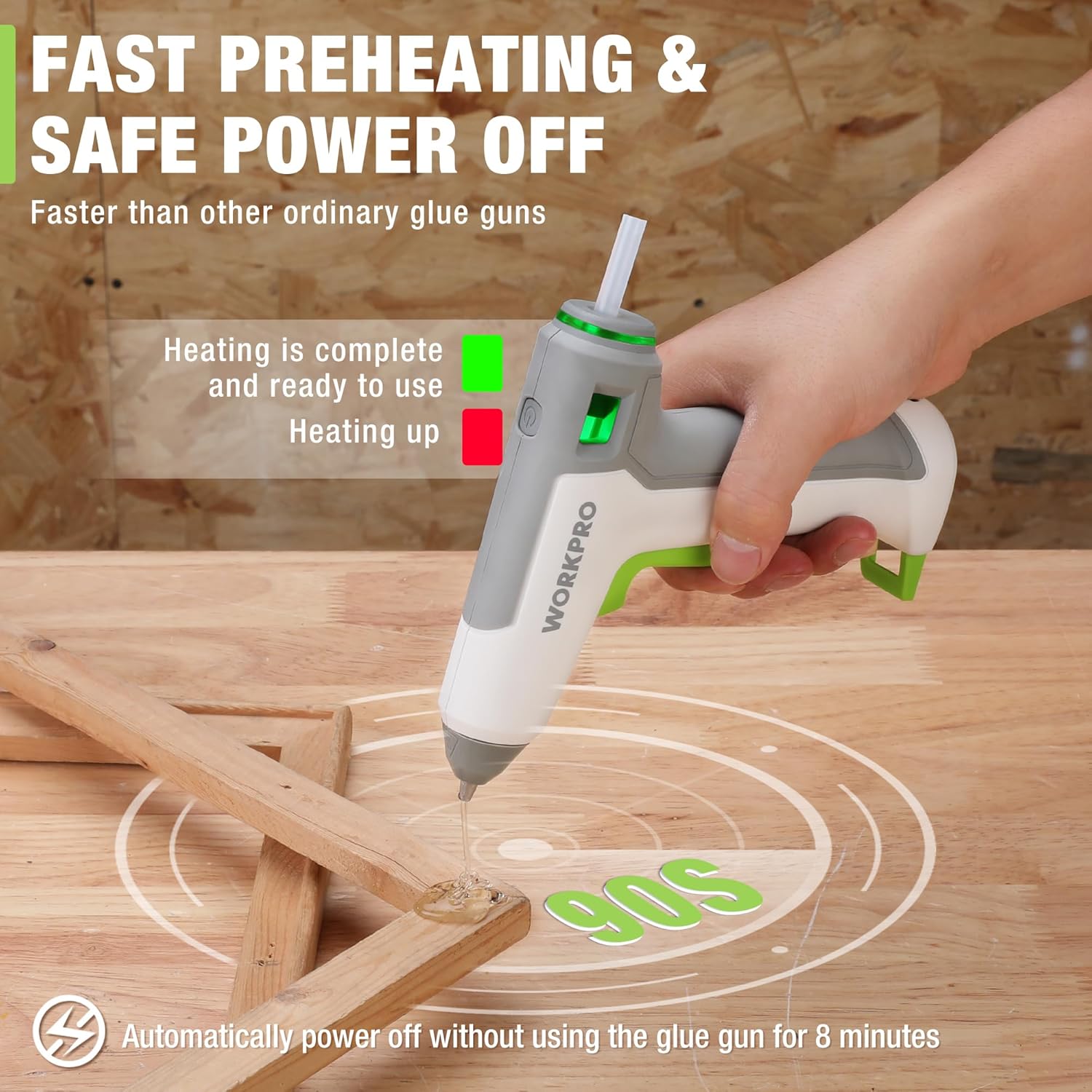 Cordless hot glue gun with green trigger dispensing a clear glue bead onto wood