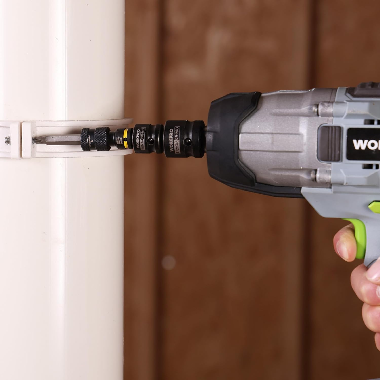 Adapter fitted to an impact driver, 1/4in square-to-hex connection, black with yellow band