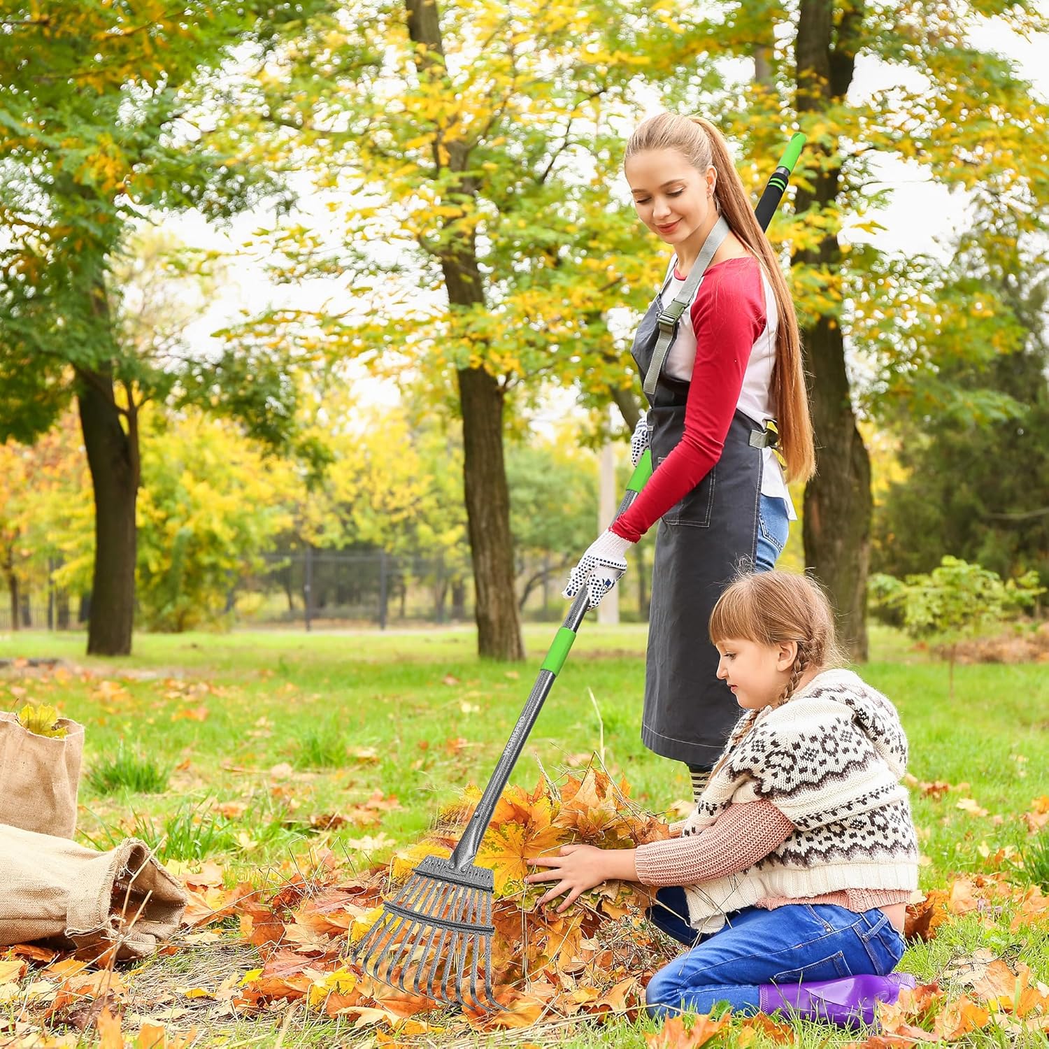 Green and silver metal leaf rake with narrow head and long adjustable handle for yard cleanup.