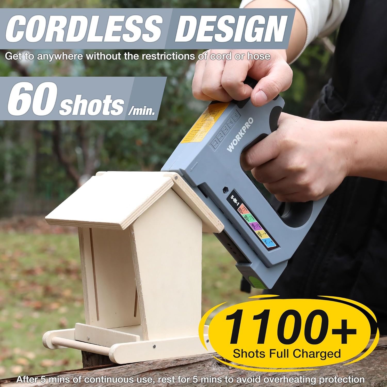 Handheld cordless electric stapler pulling trigger, aimed at light wood board
