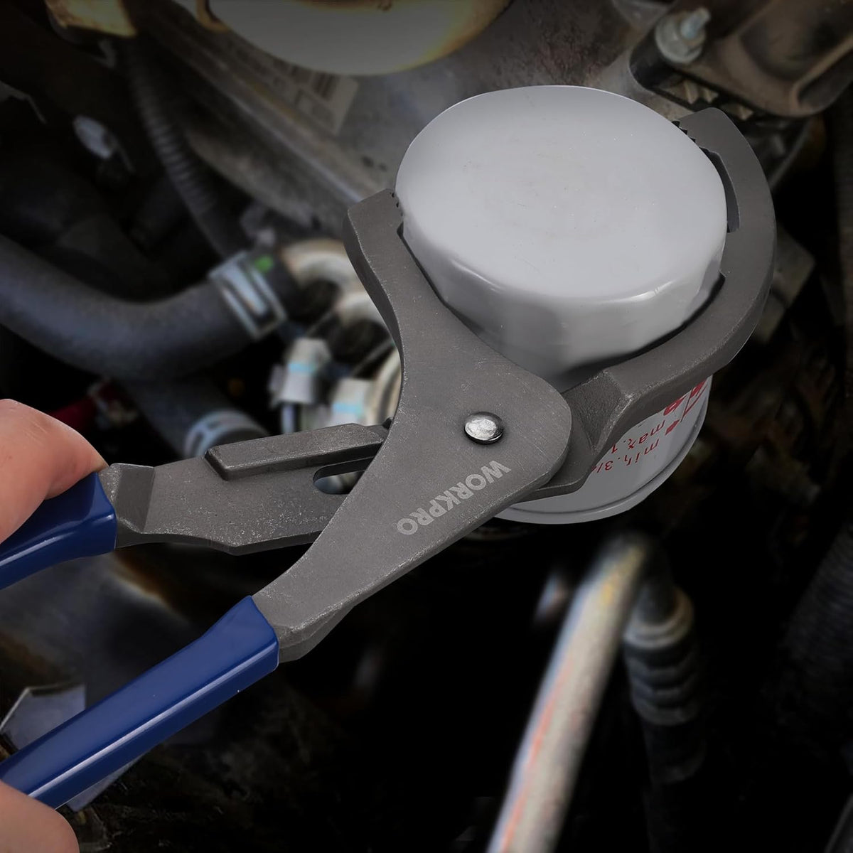 Oil filter removal wrench fitting on an engine oil filter canister with blue handles