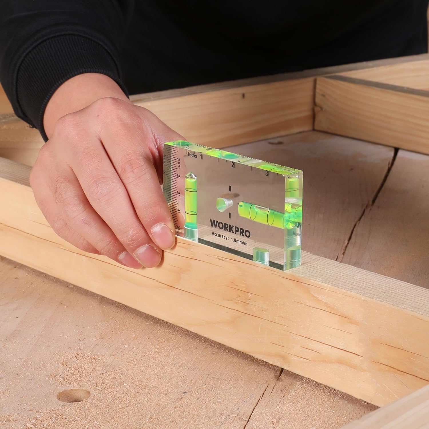 Green magnetic pocket level with clear face and inch markings placed on wood framing