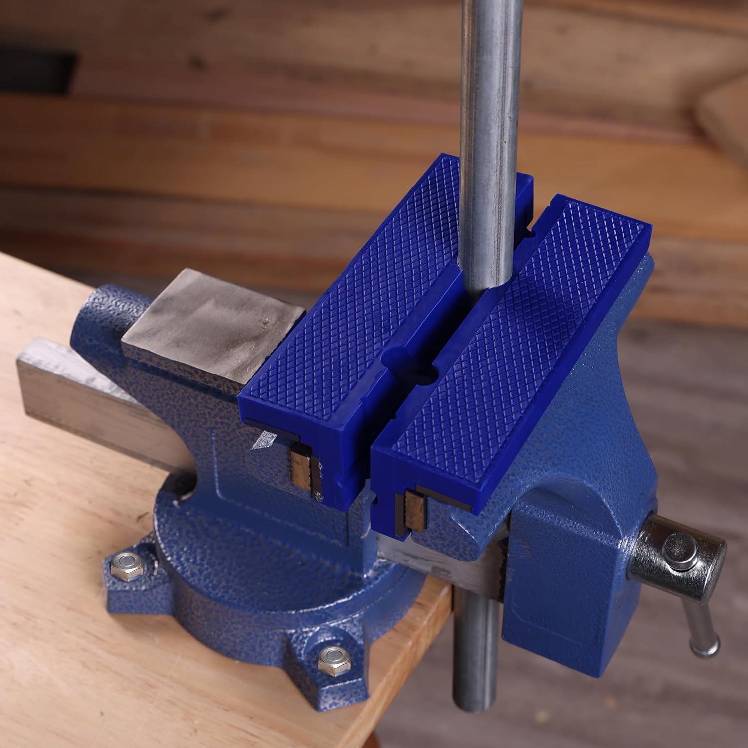 Blue TPU vise jaw pads mounted on a vise with textured grip surfaces