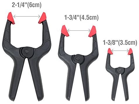 Set of black spring clamps with red jaw pads, assorted sizes labeled