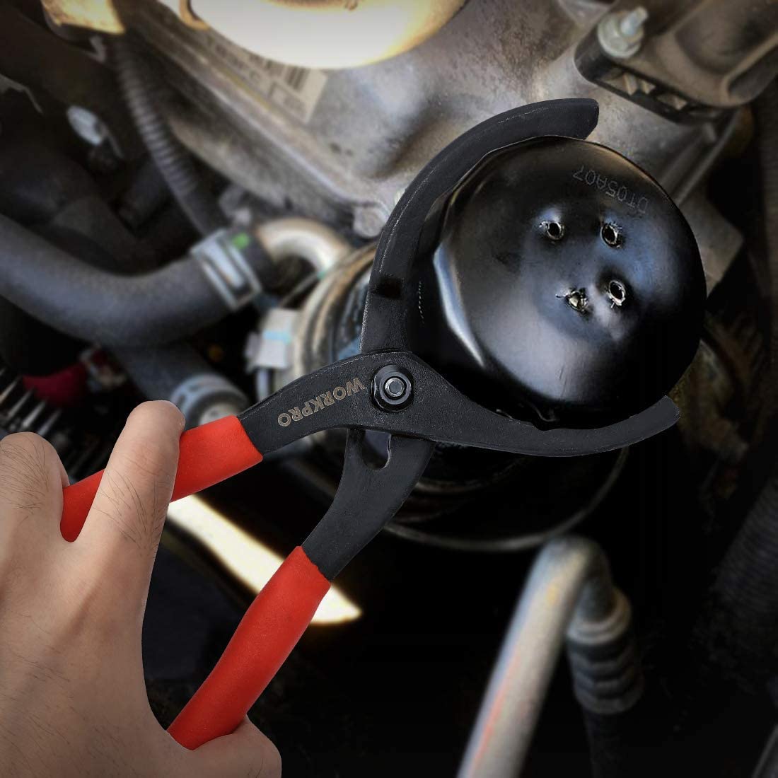 Oil filter pliers in use on a round filter housing with red and black handles
