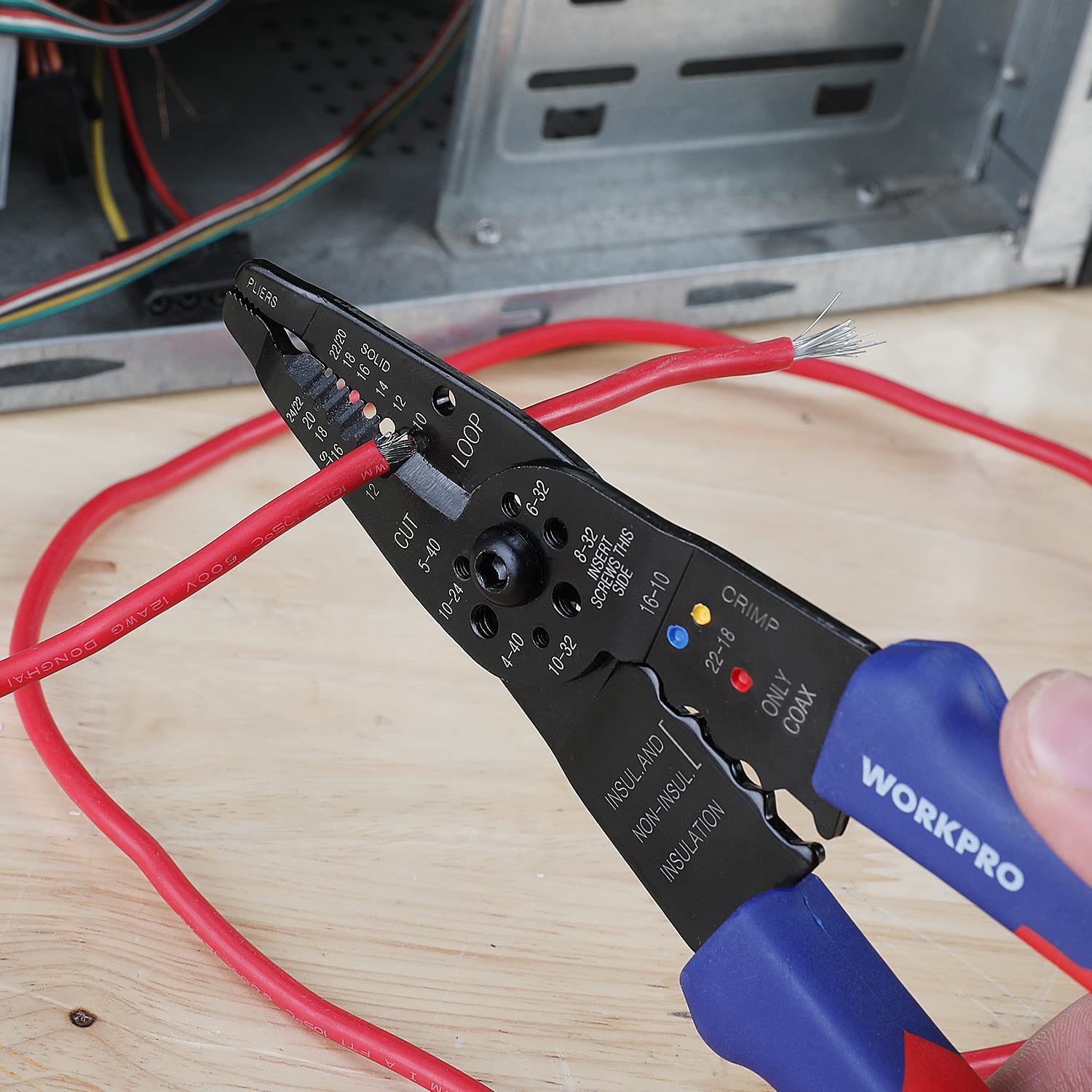 WORKPRO wire stripper pliers clamped on red insulated wires on a work surface