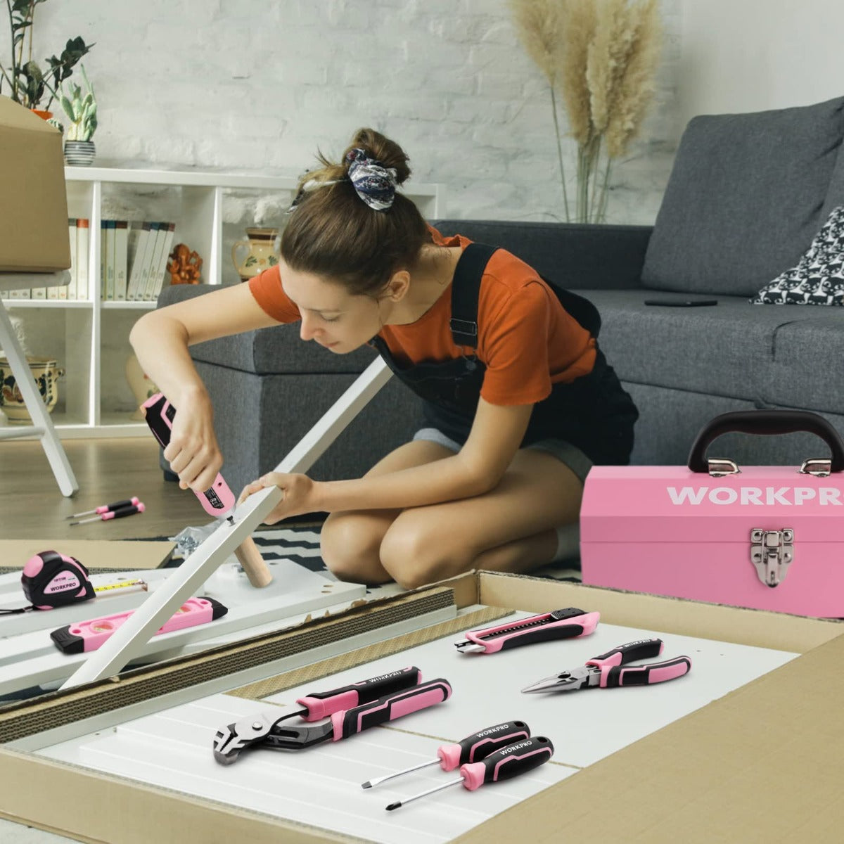Pink cordless screwdriver tool kit on a workbench with tools organized nearby