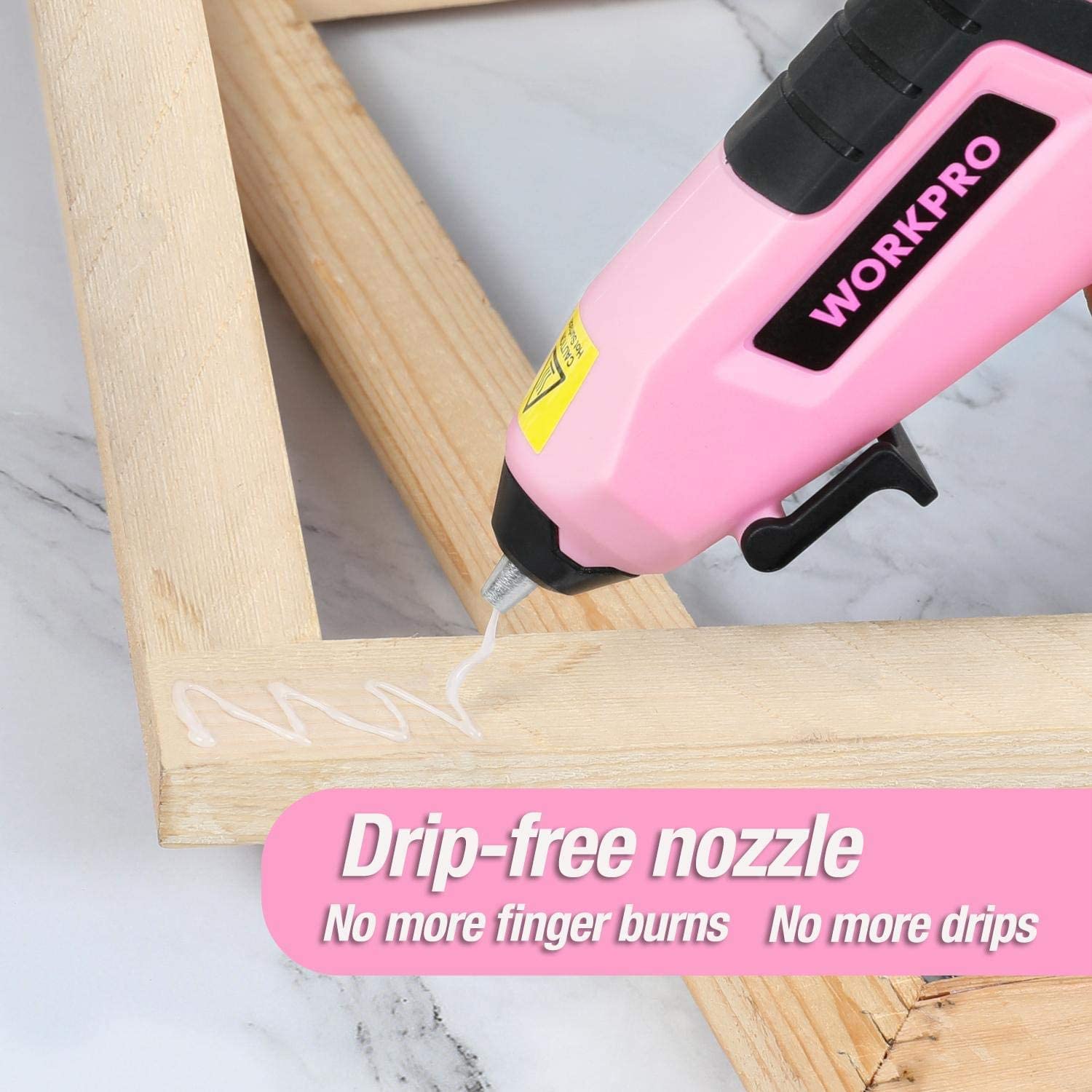 Pink mini glue gun nozzle applying clear adhesive to wooden frame; drip-free nozzle