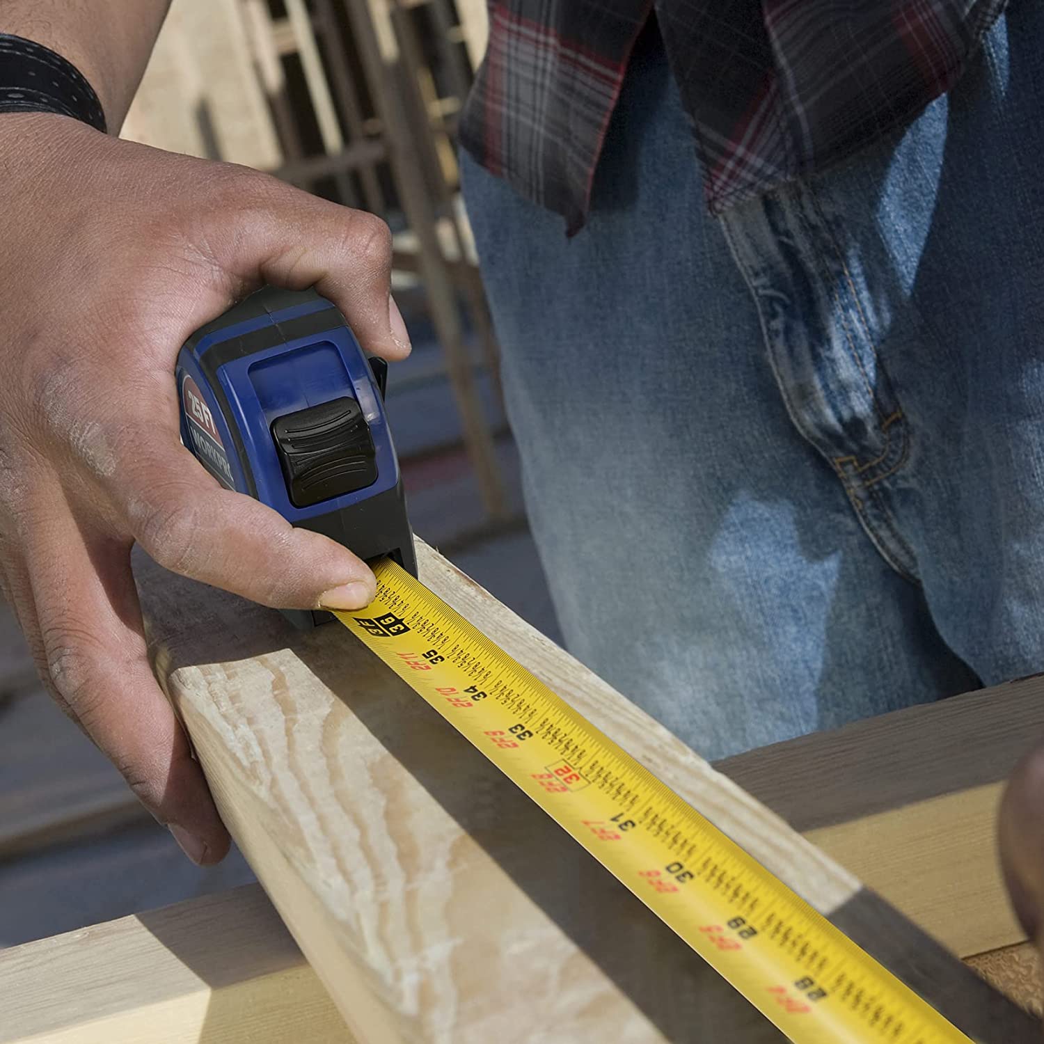 WORKPRO tape measure measuring a wood board with yellow blade