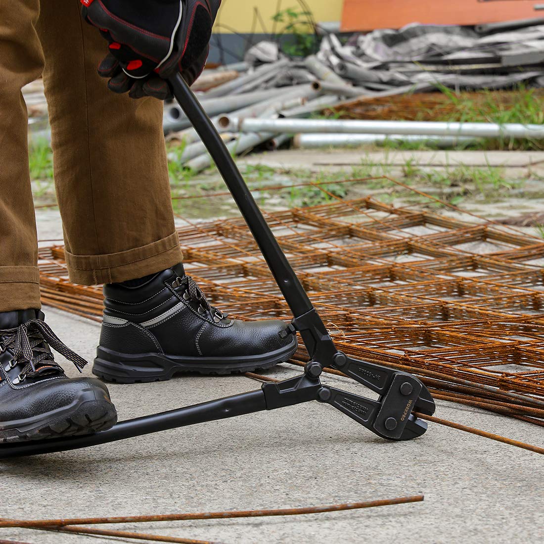 Bolt cutter cutting a rebar grid with black handles and red accents