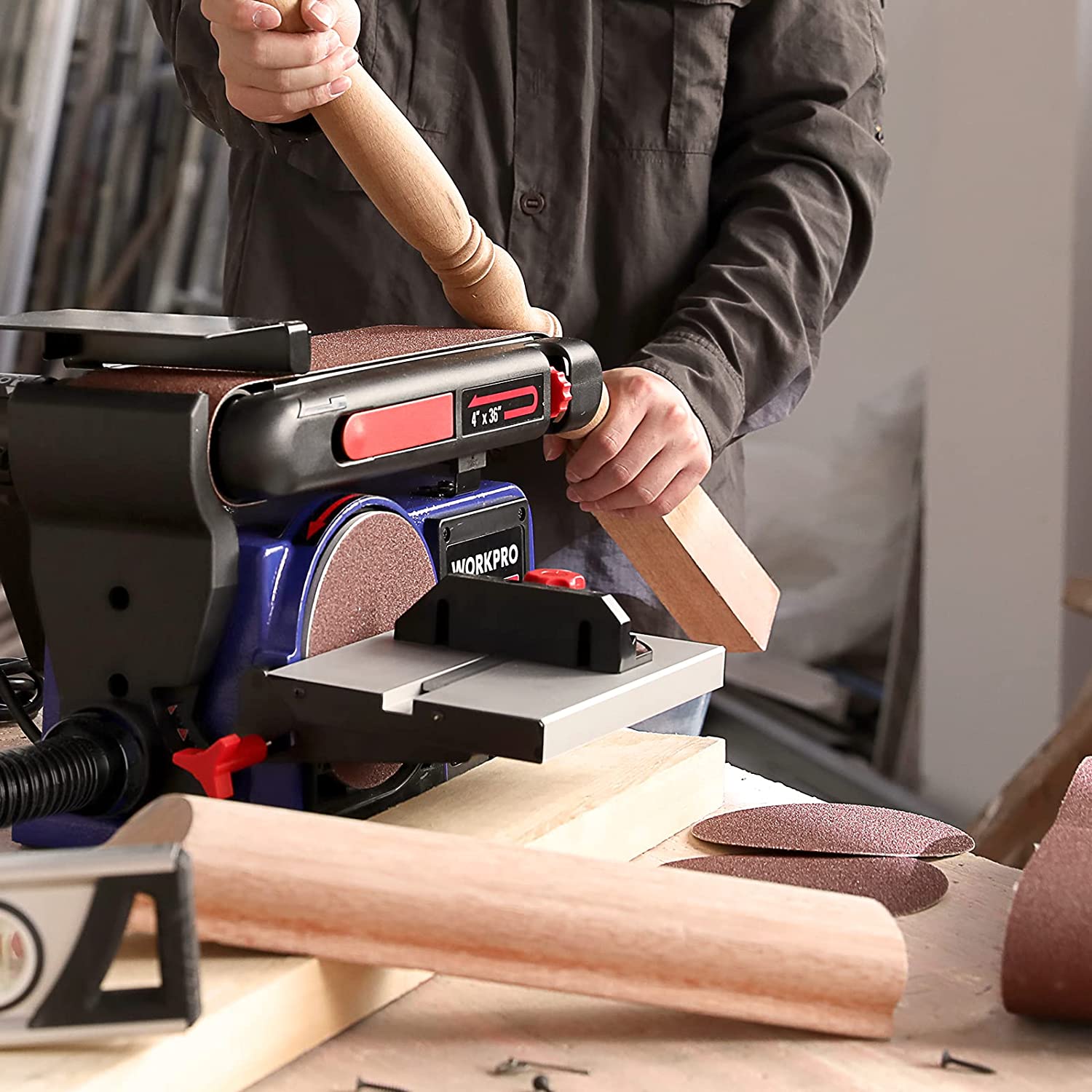 Person using belt and disc sander to smooth a wooden board on the bench