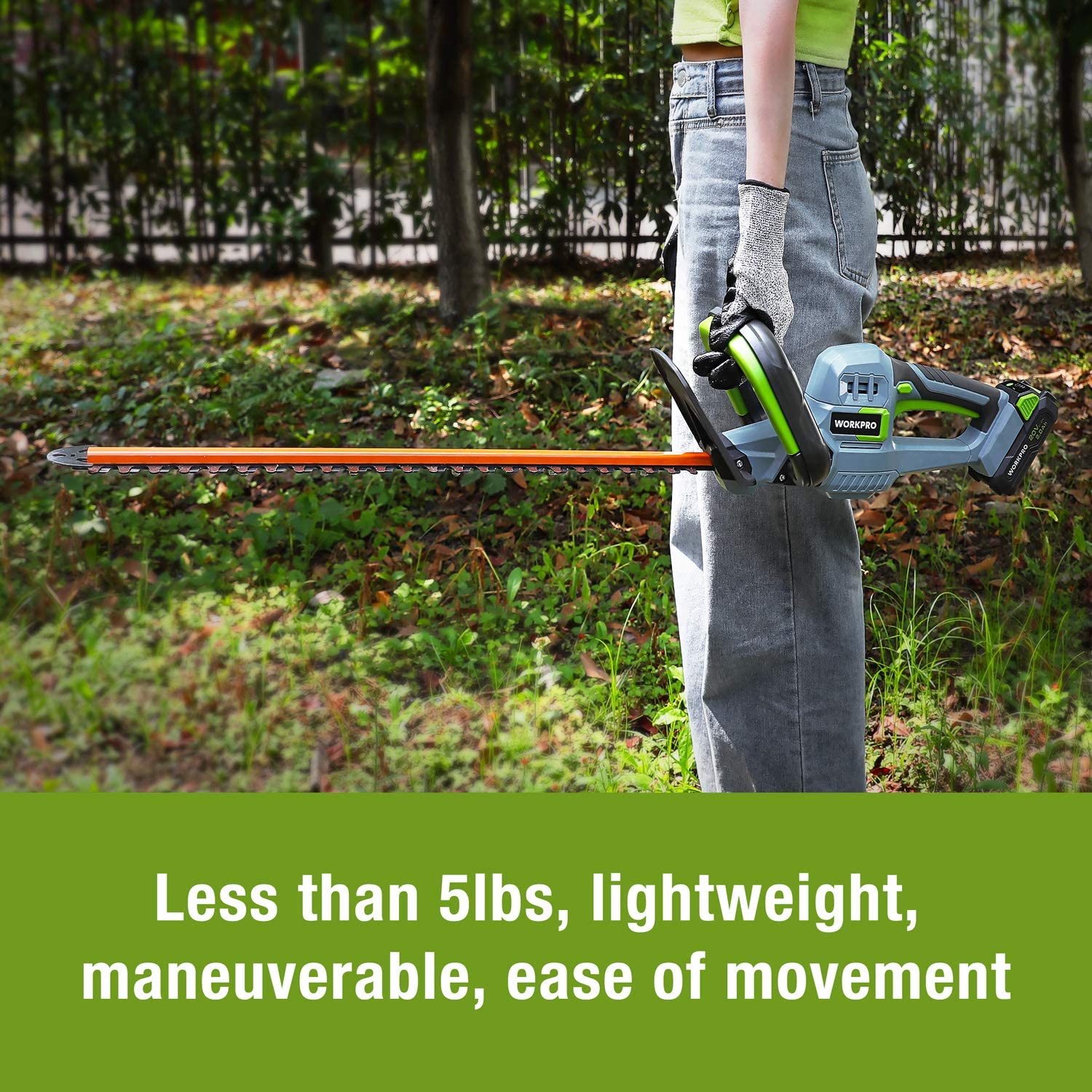 Hedge trimmer cutting position near ground, orange blade with green safety accents
