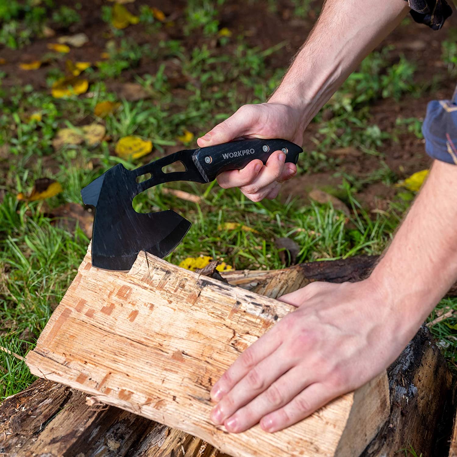 Axe with wooden handle and black head held for splitting wood
