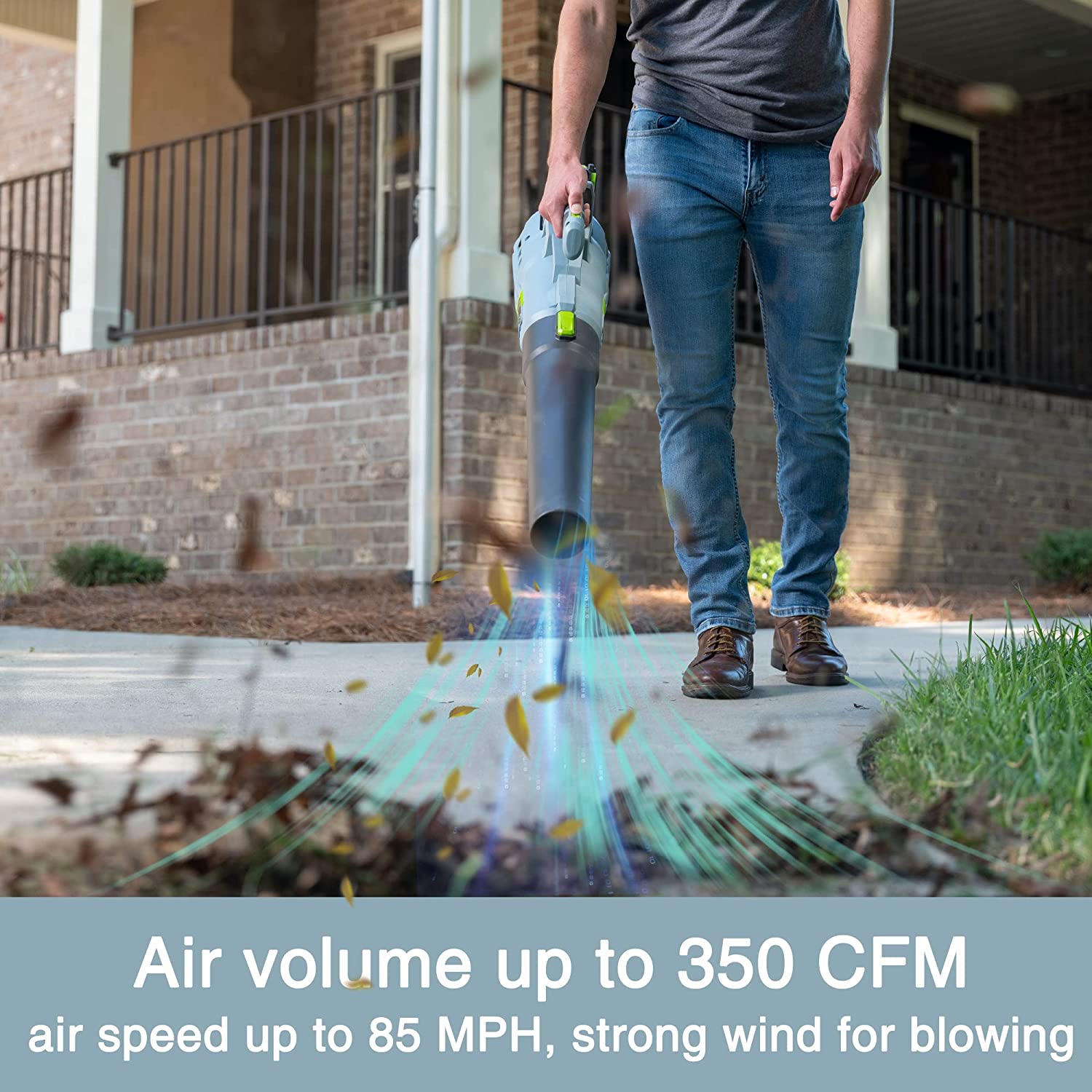 Cordless leaf blower emitting airflow from black nozzle while walking on driveway