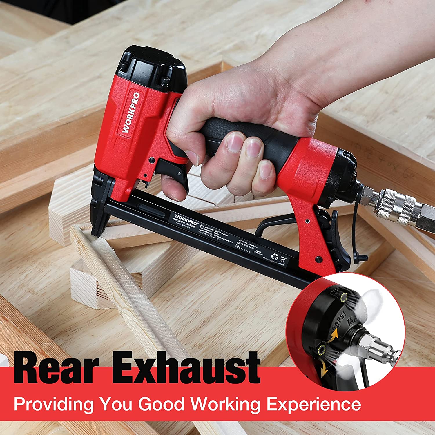 Pneumatic staple gun with rear exhaust and front nose on wood surface
