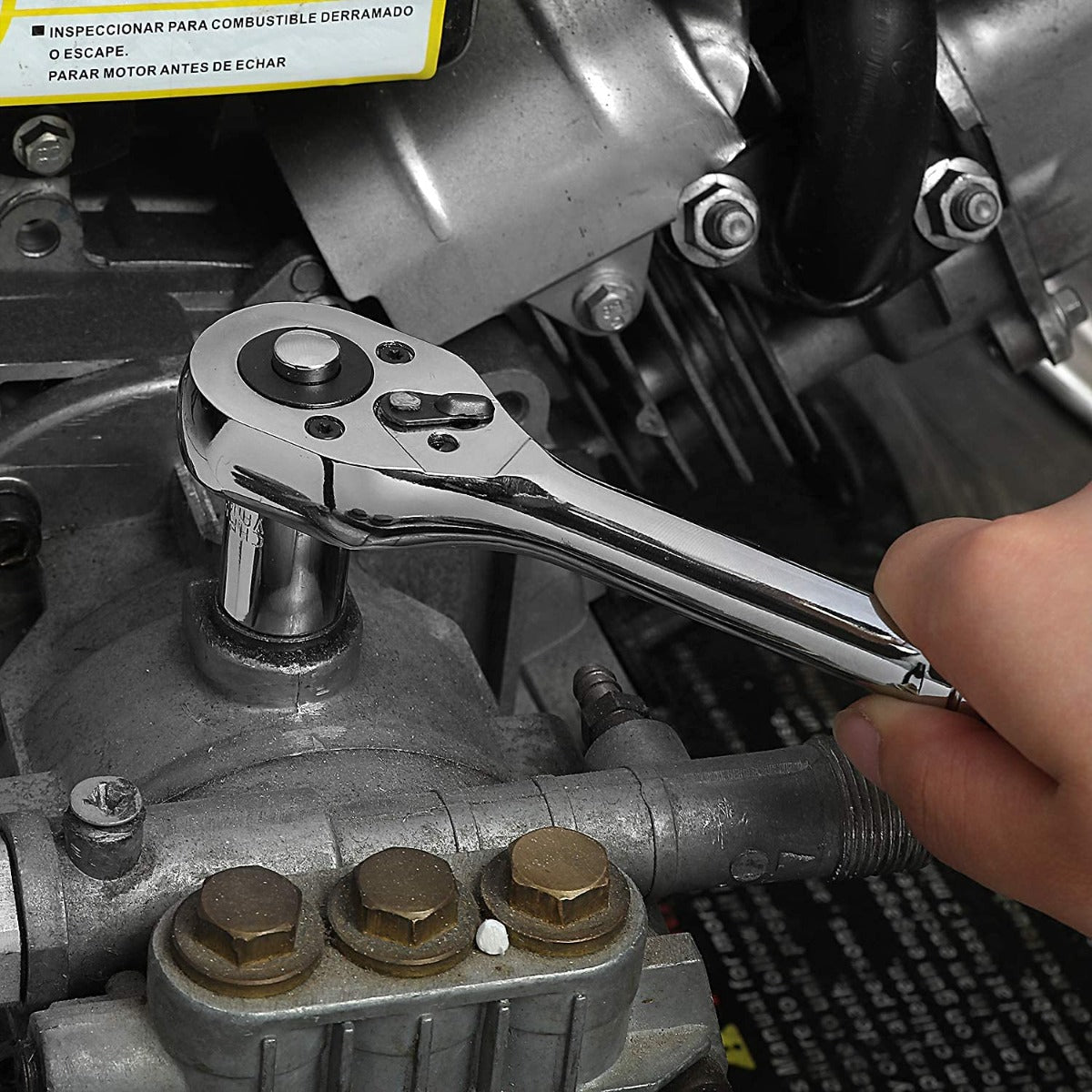 Chrome ratchet wrench turning a bolt with a reversible drive head