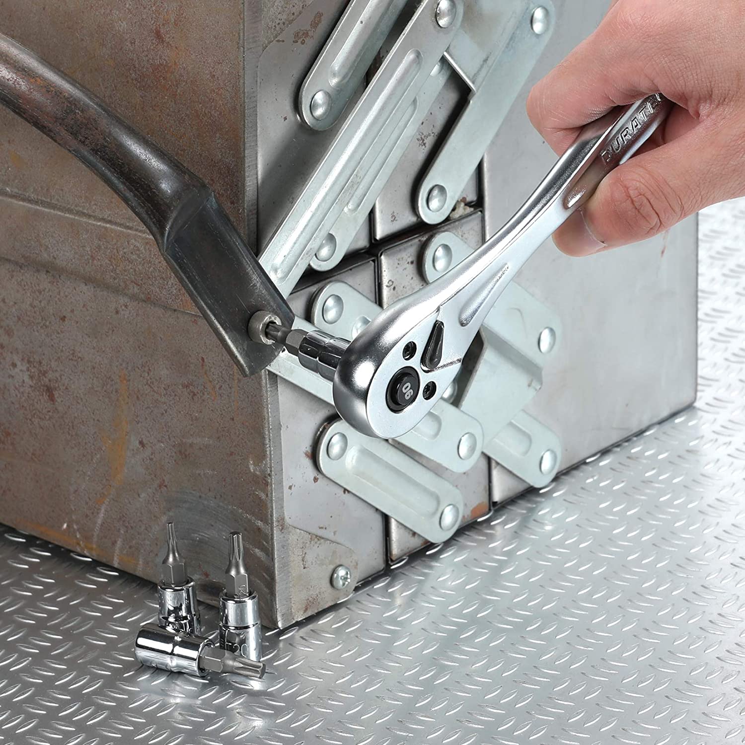 Torx bit socket on a metal bracket, tightened by a hand using a ratchet
