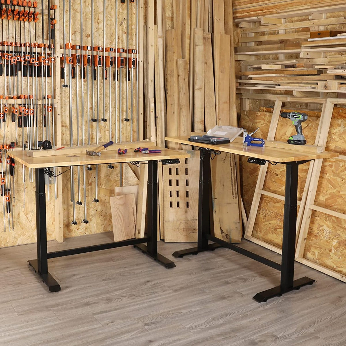 Adjustable workbench with light wood top and black steel legs in workshop