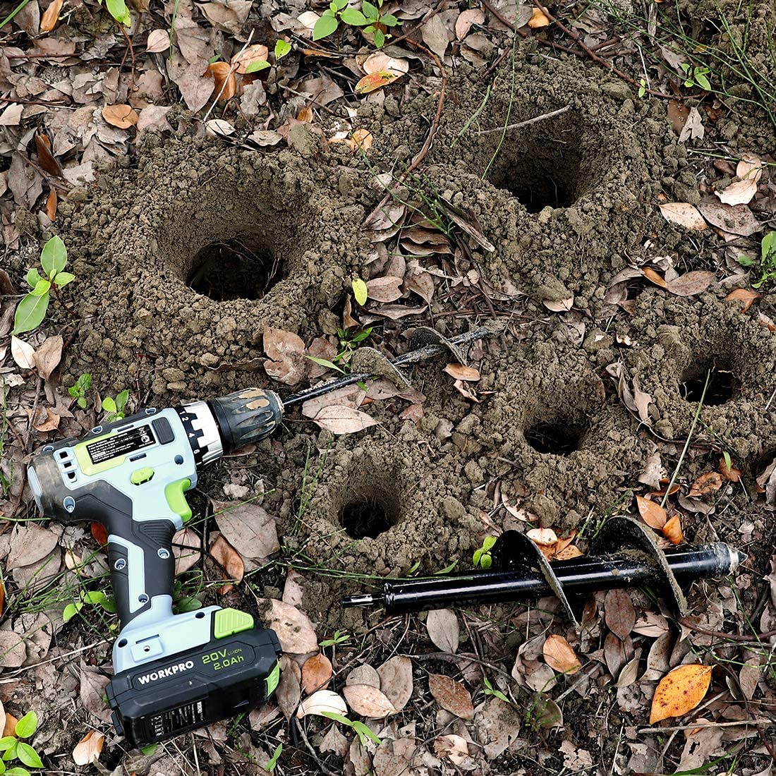 Spiral auger drill bit drilling holes in soil with helical screw flights