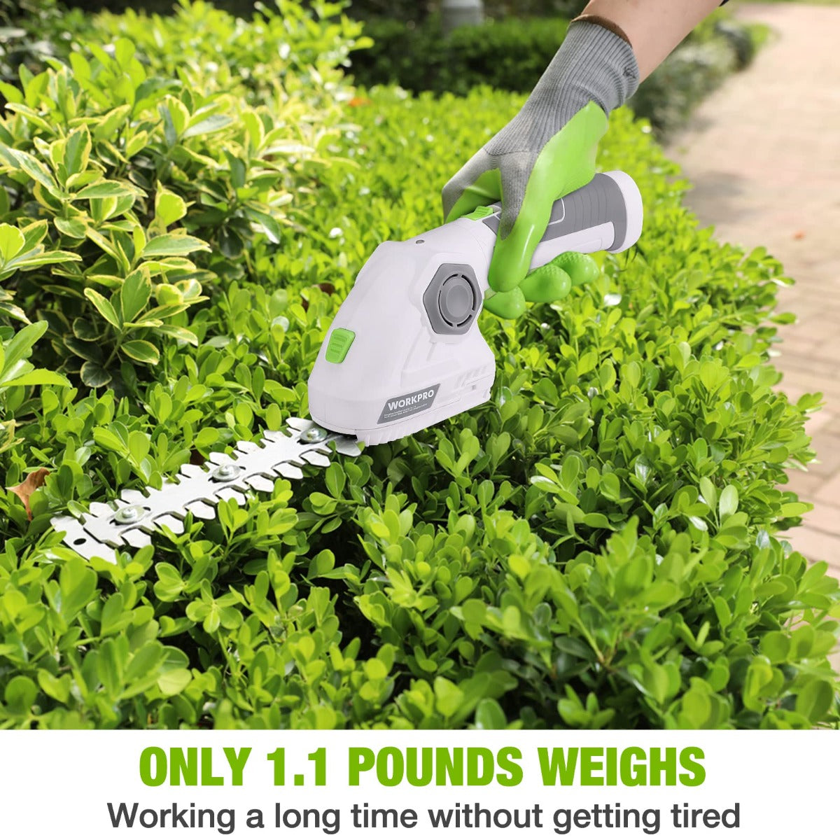 Handheld hedge trimmer cutting green shrubs; white body with green grip accents