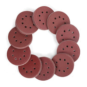 Round red sanding discs with dark perforations, stacked in a ring
