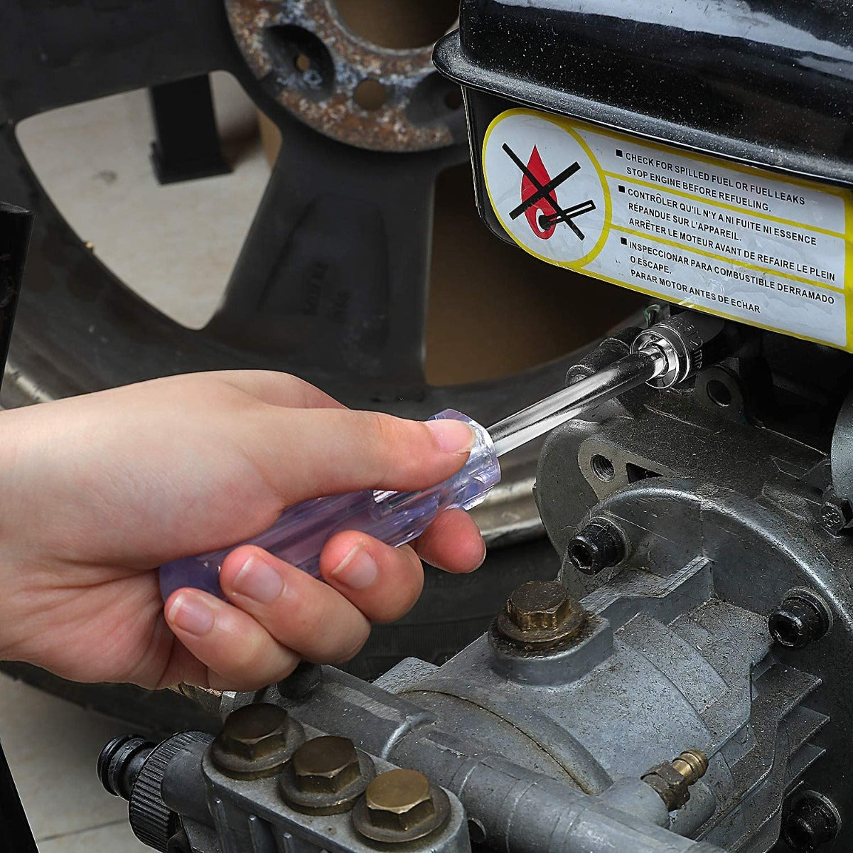 Chrome ratchet wrench held by hand tightening a bolt in a workshop application